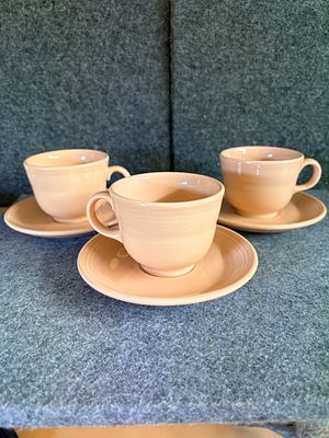 A Collection of Peach Genuine Fiesta Ceramic Cups and Saucers. A collection of peach-colored 