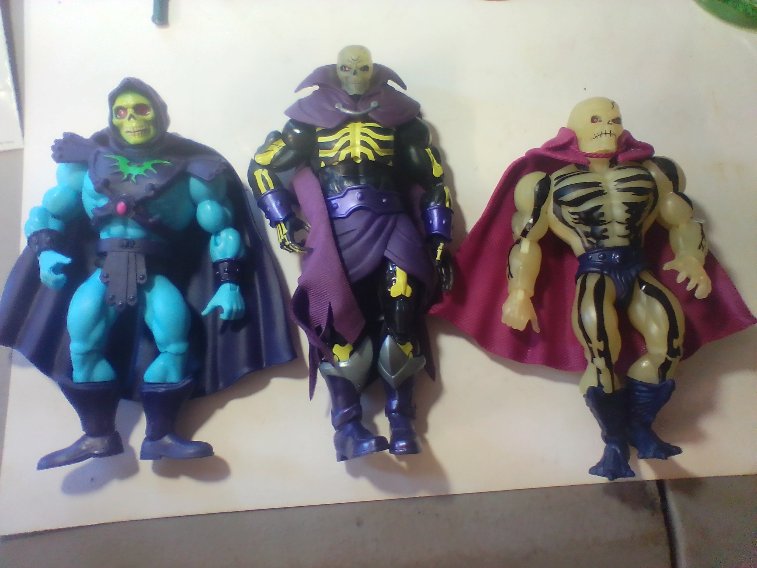 An Assortment of Masters of the Universe Action Figures and Accessories Featuring Skeletor and Scare Glow