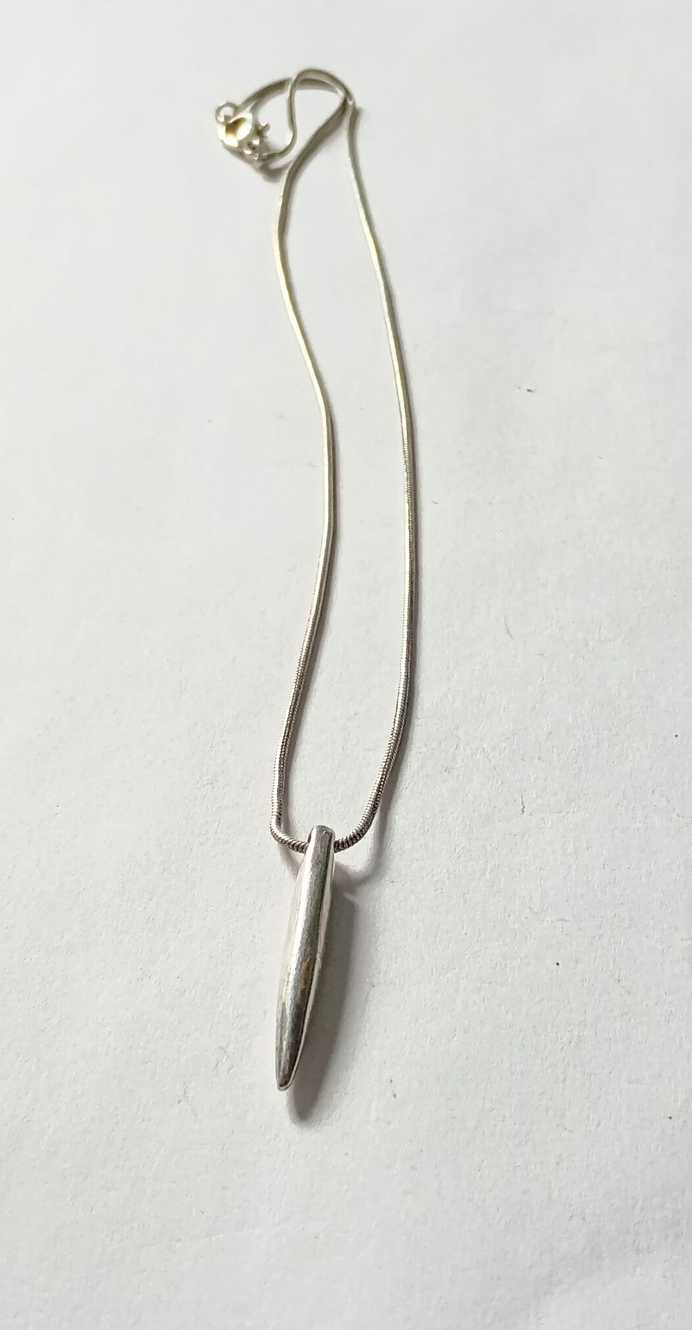 Lot 213: Single solid bar pendant on chain
