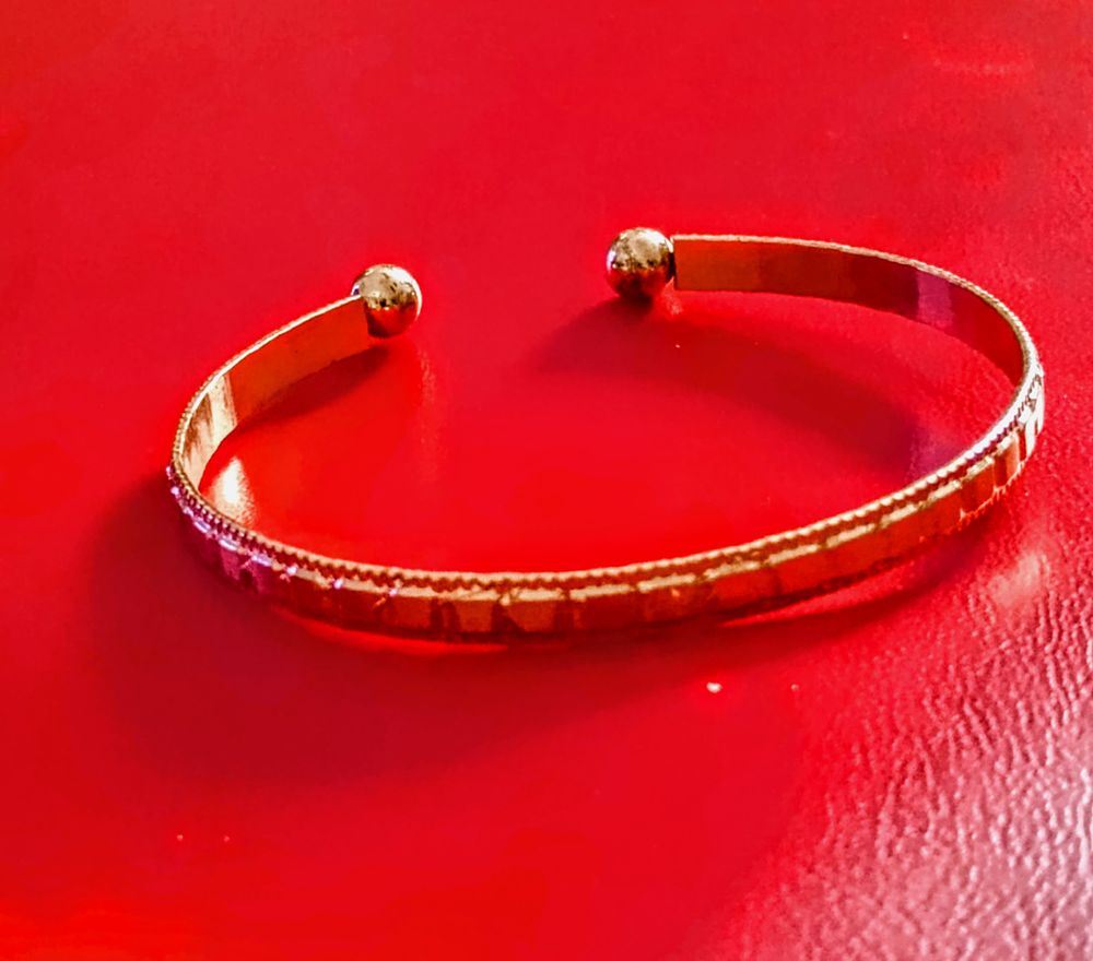 Lot 162: open-ended gold-tone torque bracelet
