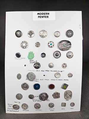 A Collection of Modern Pewter Buttons Including Todd Oldham and Three Feathers Pewter. A 
