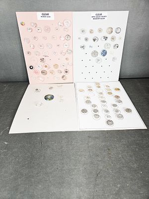 A Collection of Modern Glass Buttons. A collection of modern glass buttons organized across four 