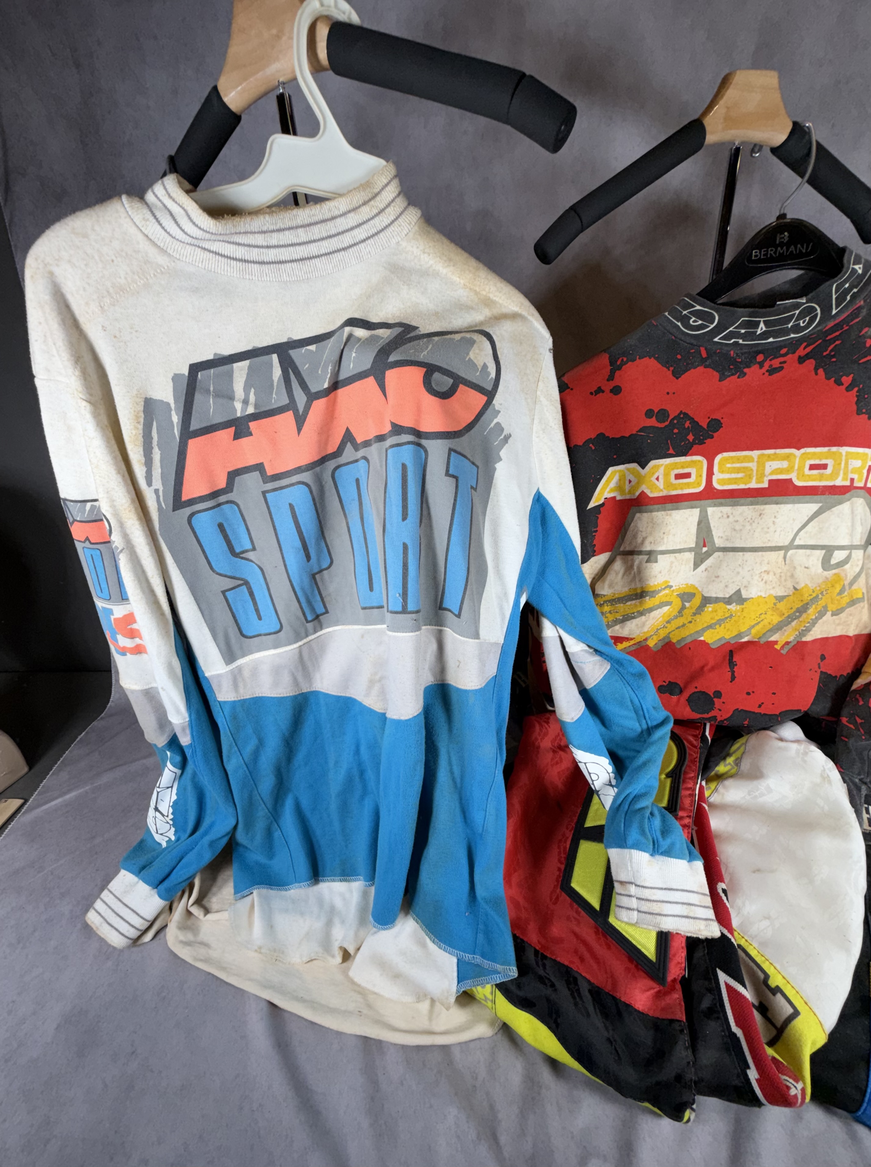 A Collection of Five Vintage AXO Sport Motocross Racing Jerseys and Pants Including Damon Bradshaw Edition Items