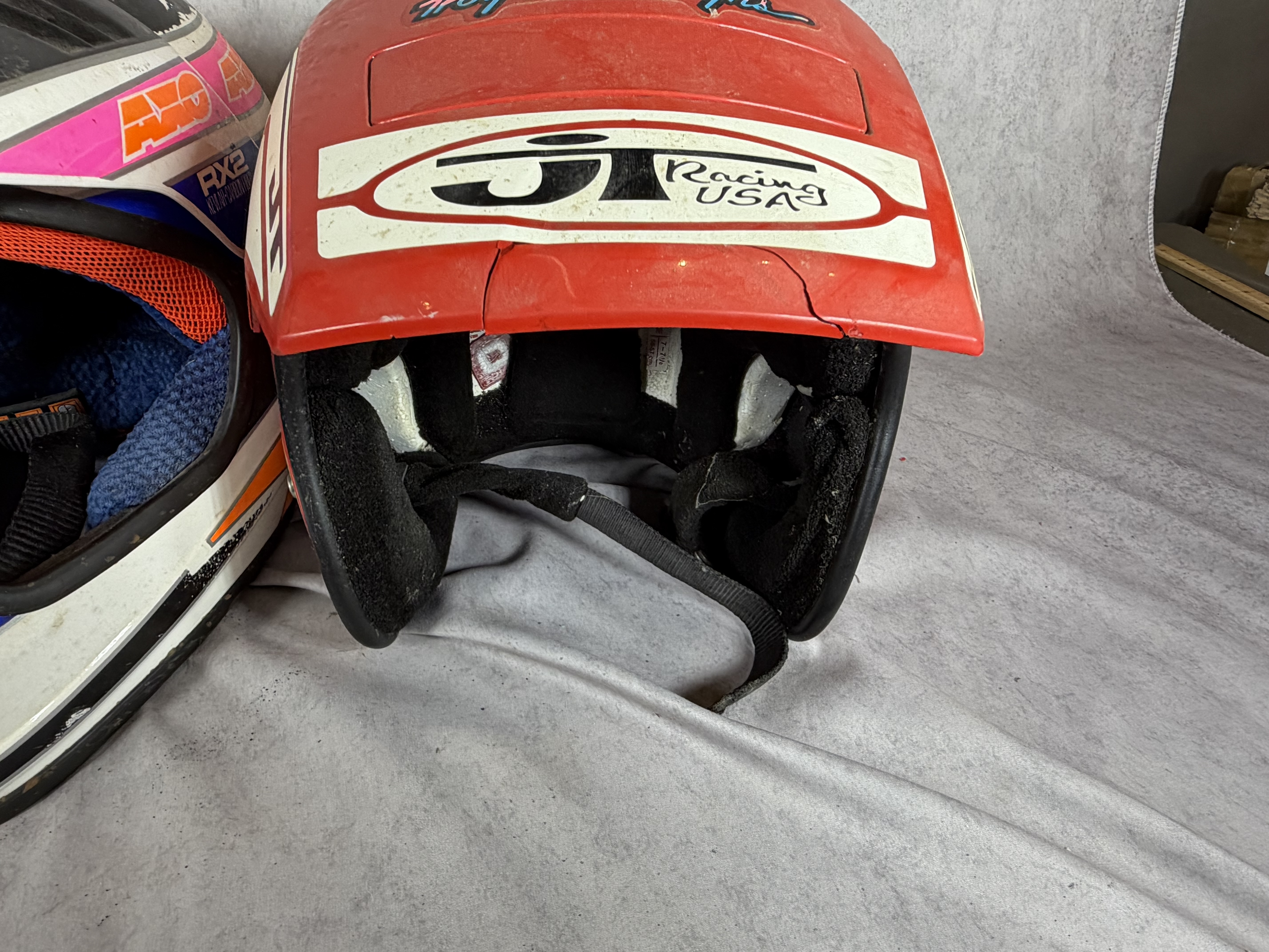 A Trio of Vintage Motorcycle Helmets Including Shark Carl Fogarty Replica, AXO Sport RX2, and Bell JT Racing USA