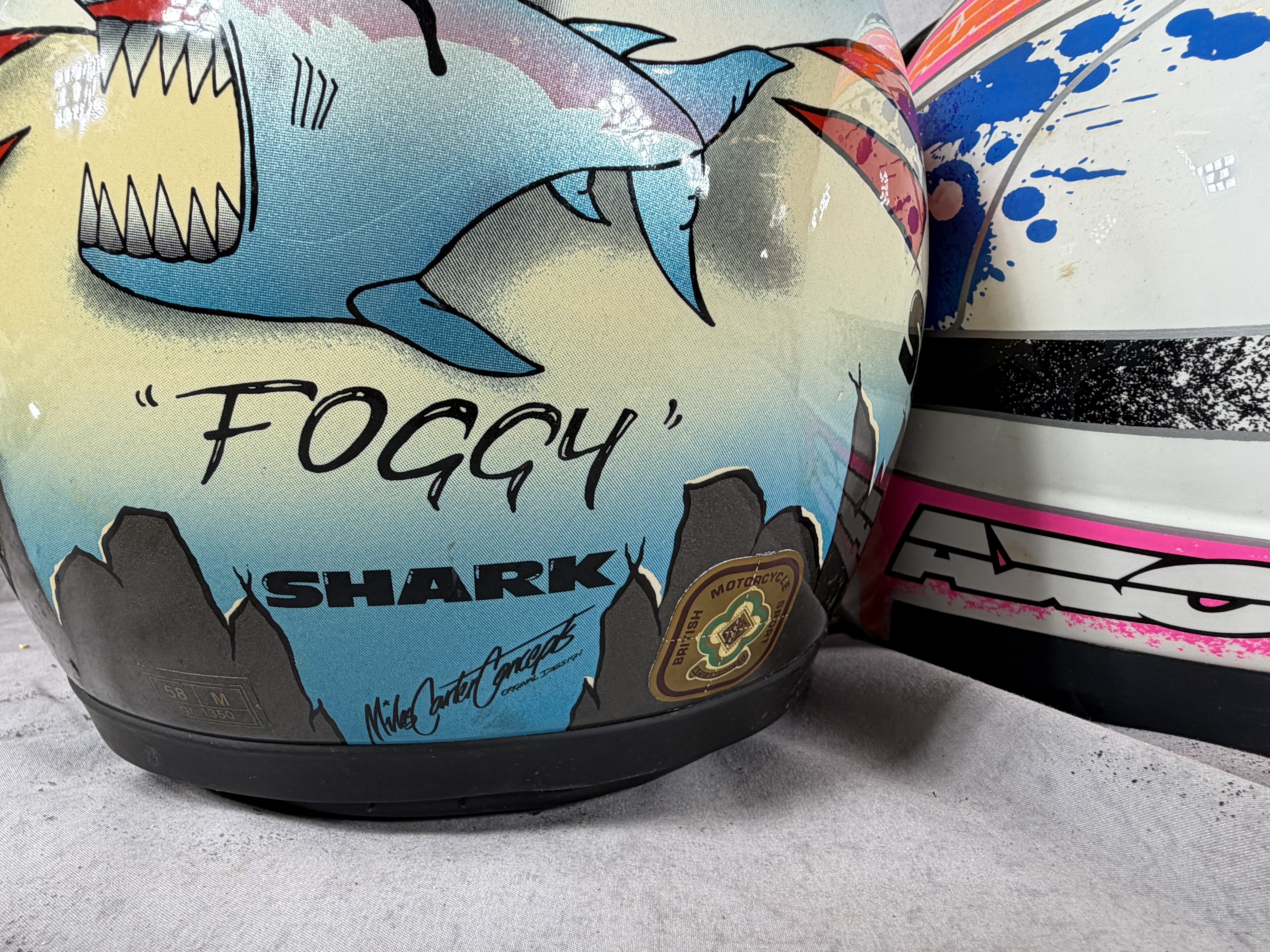 A Trio of Vintage Motorcycle Helmets Including Shark Carl Fogarty Replica, AXO Sport RX2, and Bell JT Racing USA