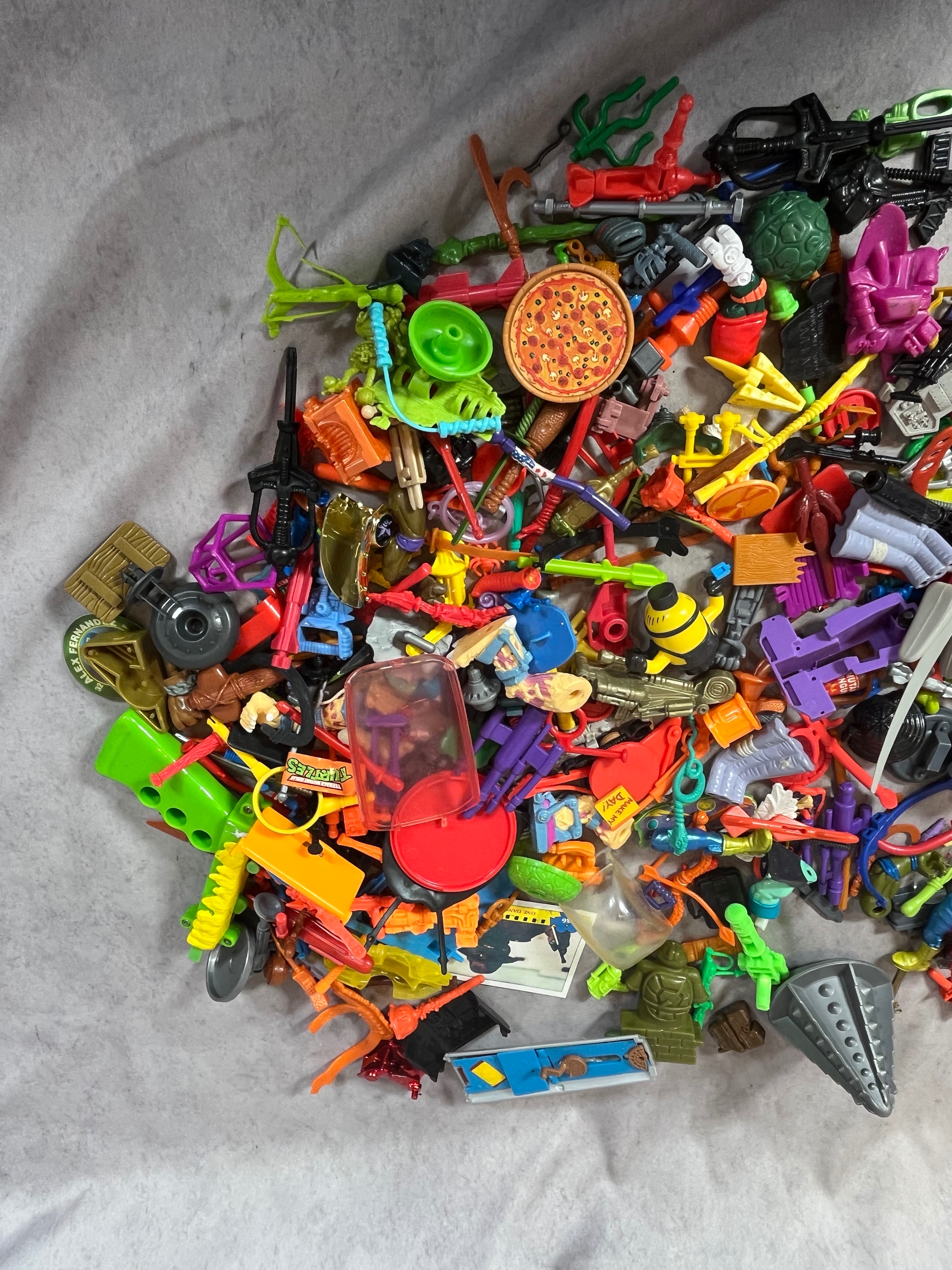 A Collection of Vintage Teenage Mutant Ninja Turtles and Contemporary Action Figure Accessories and Parts