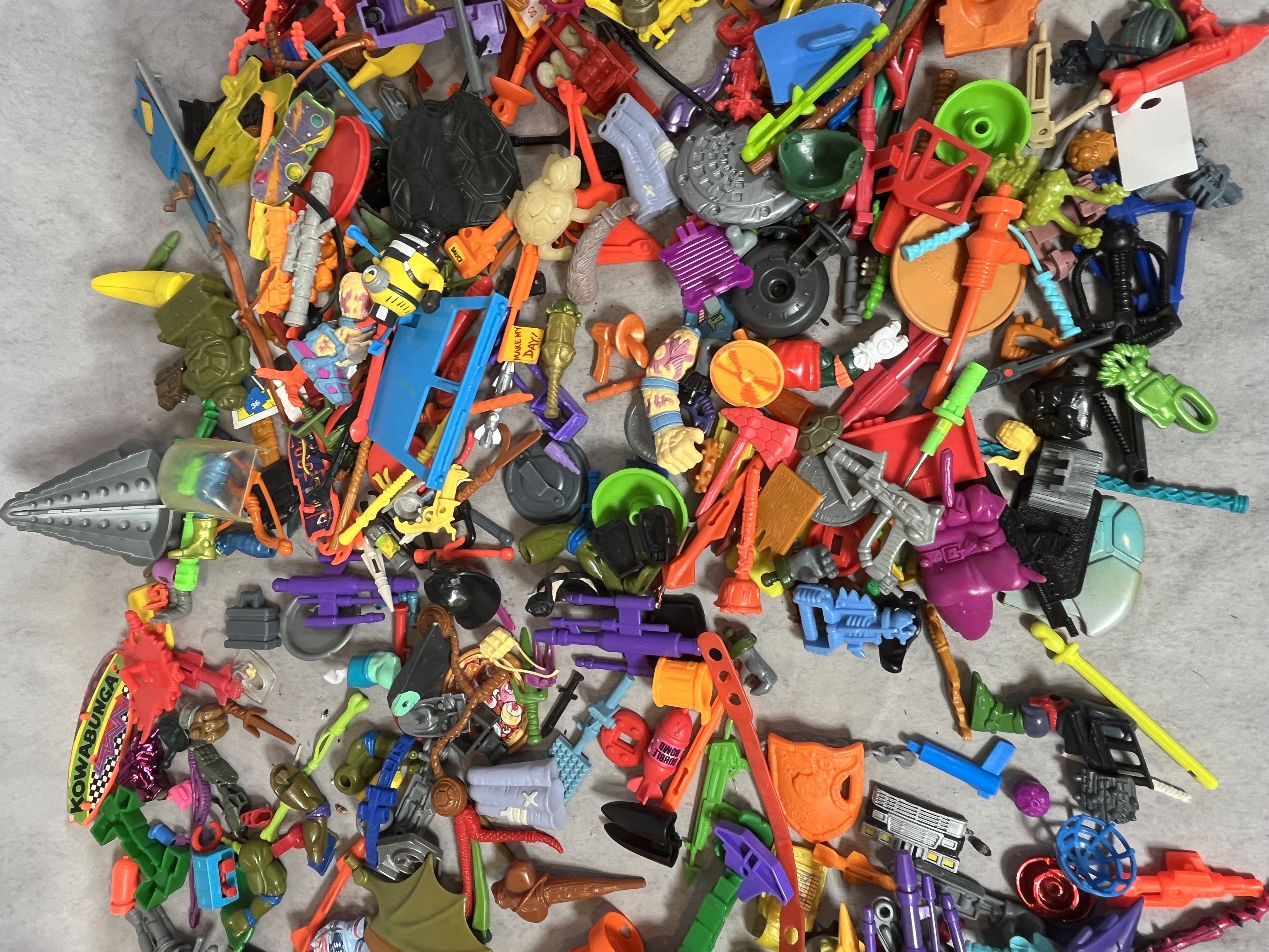 A Collection of Vintage Teenage Mutant Ninja Turtles and Contemporary Action Figure Accessories and Parts