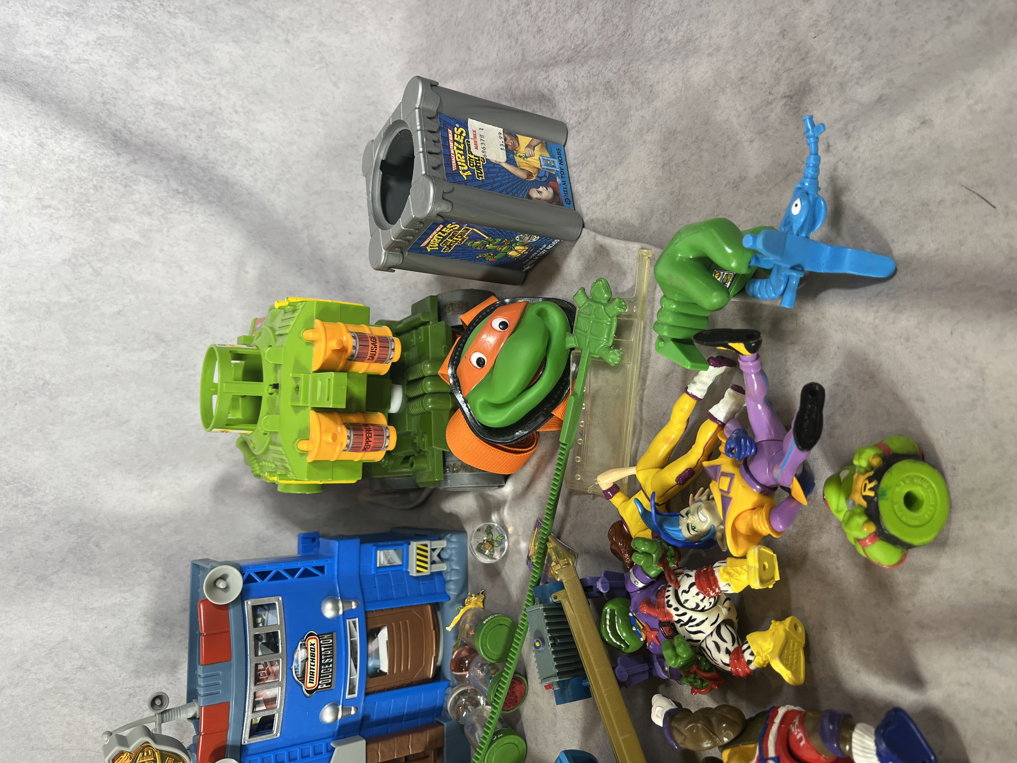 An Assortment of Vintage Teenage Mutant Ninja Turtles Action Figures, Vehicles, and Play-set Components by Playmates and Matchbox