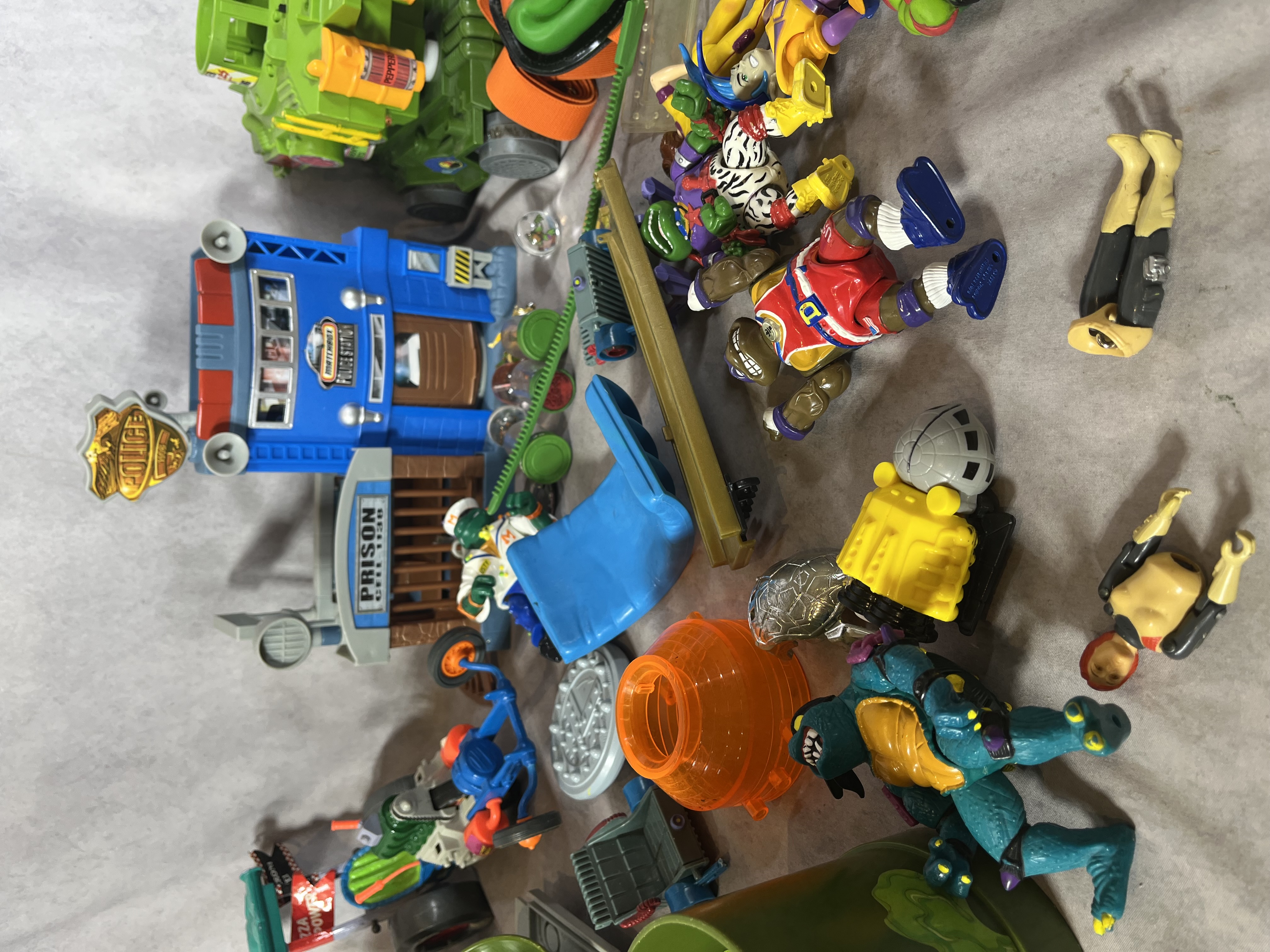 An Assortment of Vintage Teenage Mutant Ninja Turtles Action Figures, Vehicles, and Play-set Components by Playmates and Matchbox