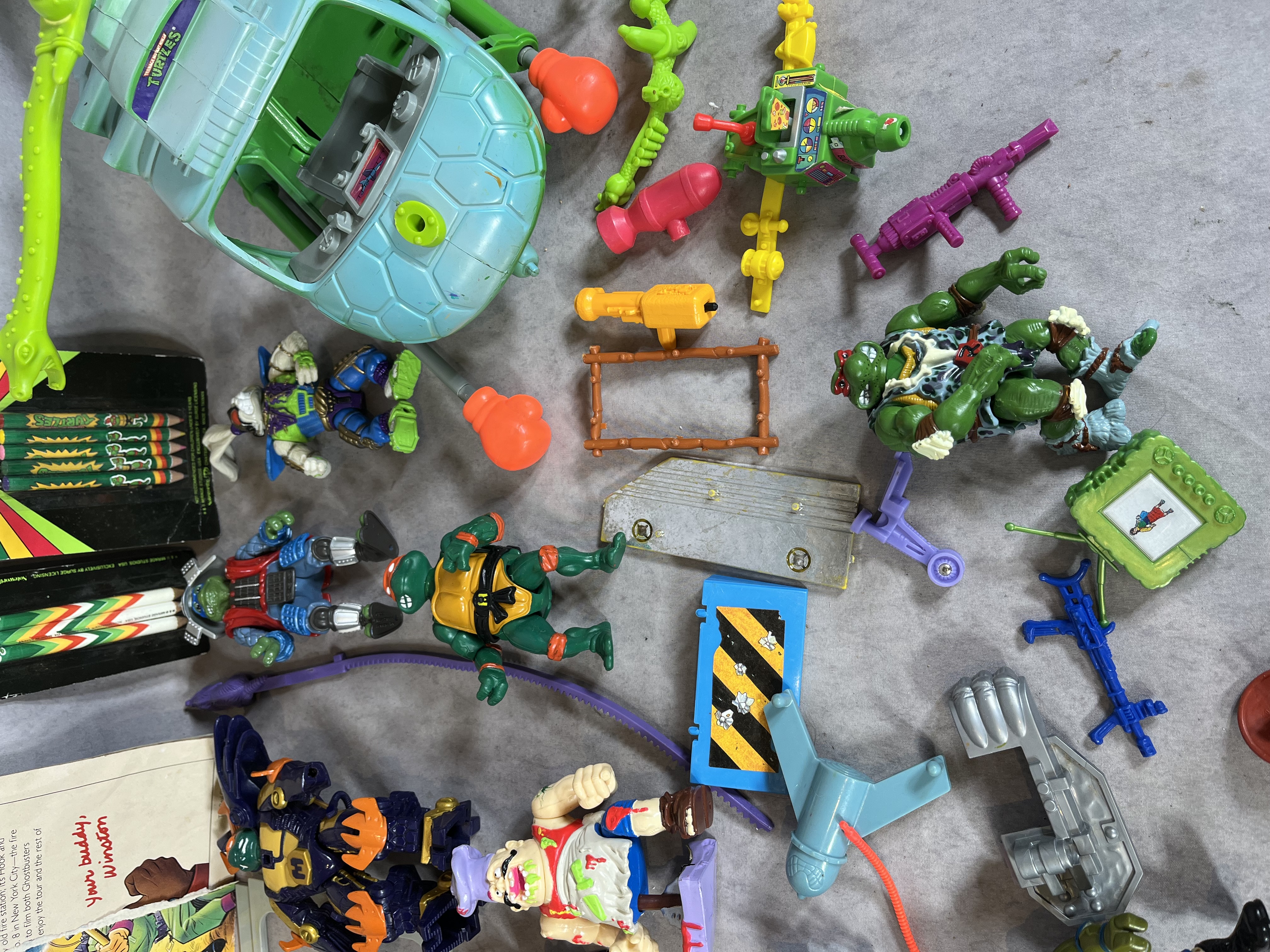 A Collection of Vintage Teenage Mutant Ninja Turtles Playmates Toys Action Figures, Vehicles, and Real Ghostbusters Ephemera