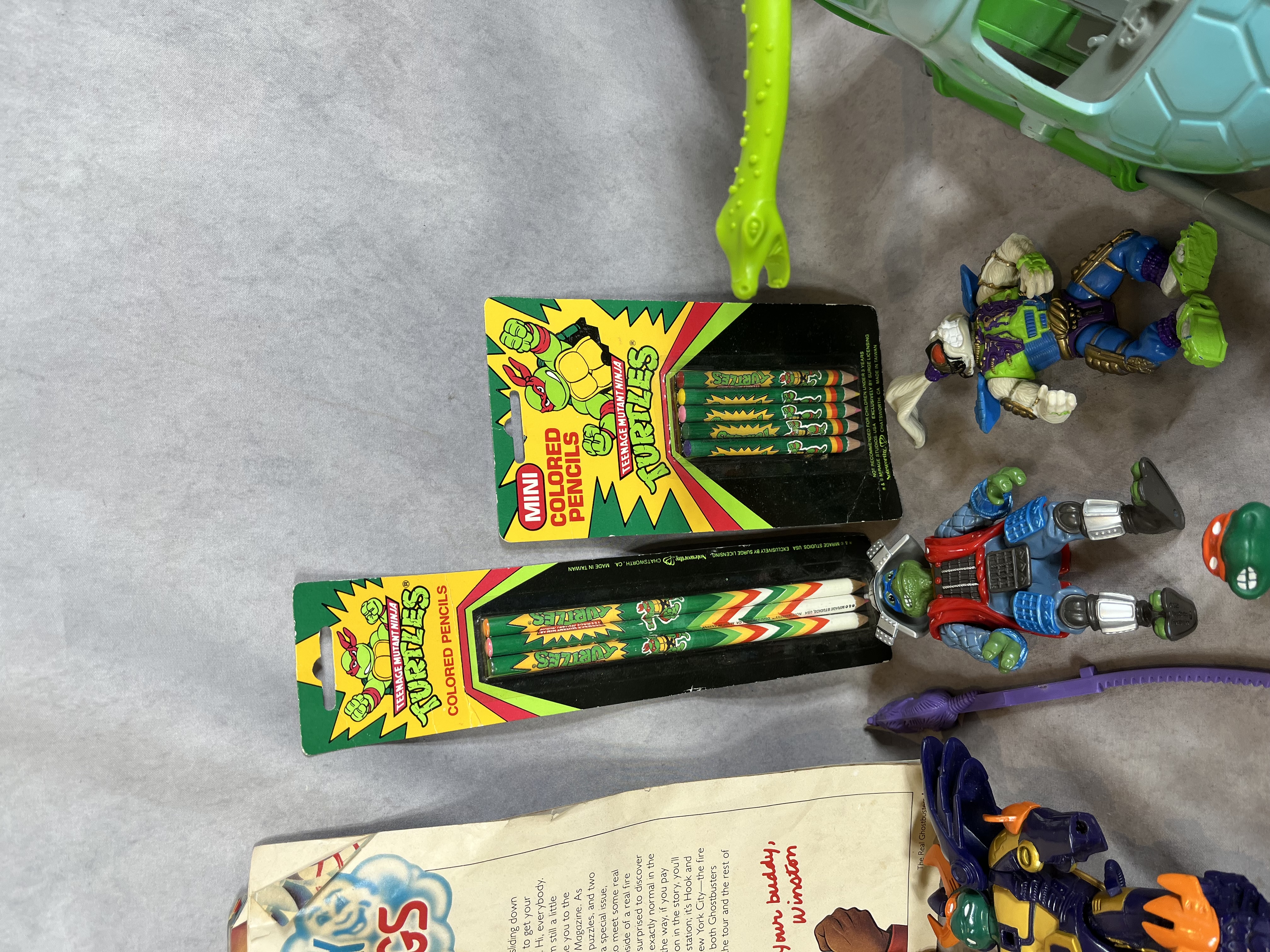 A Collection of Vintage Teenage Mutant Ninja Turtles Playmates Toys Action Figures, Vehicles, and Real Ghostbusters Ephemera