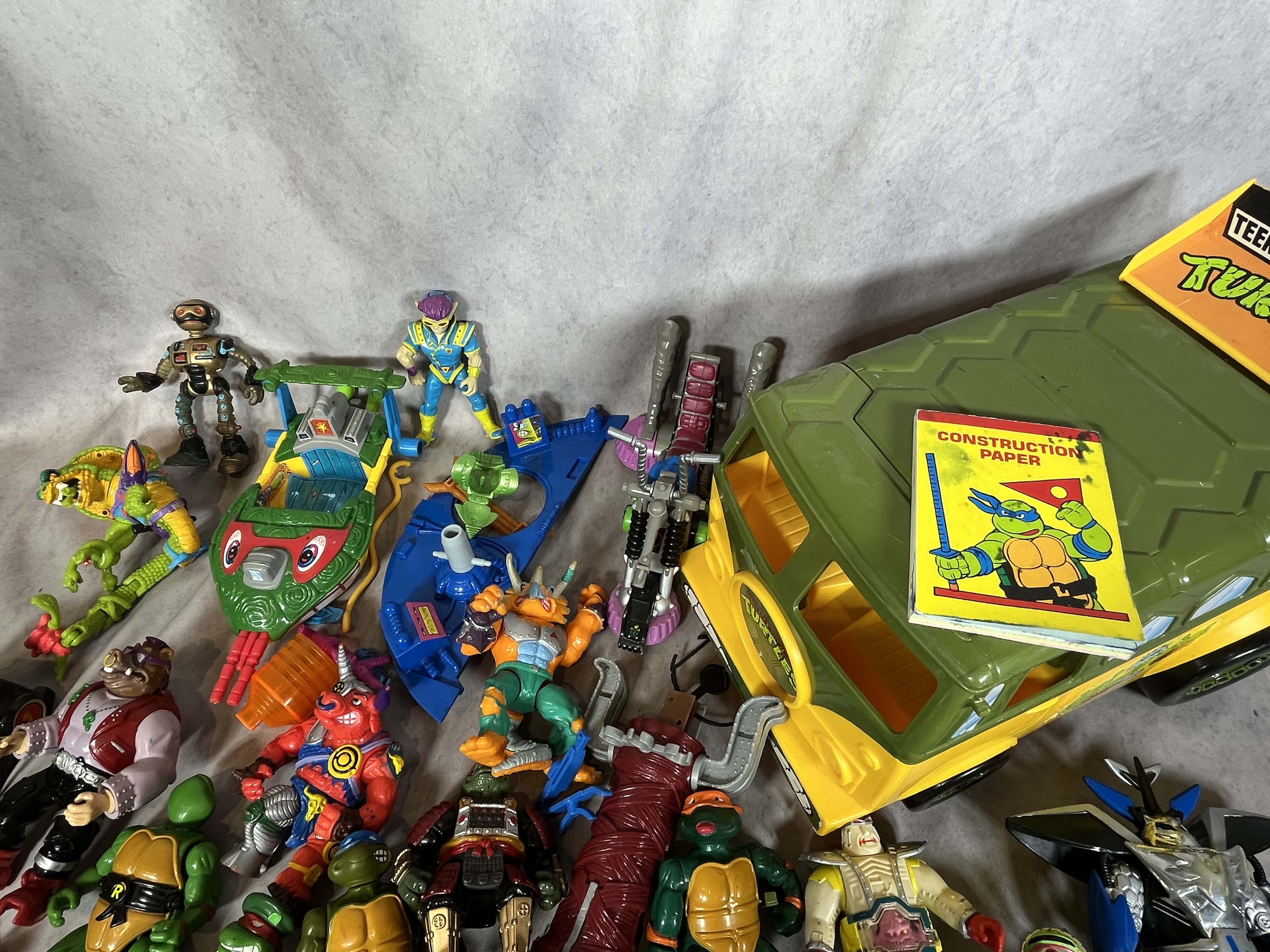 A Collection of Vintage Playmates Teenage Mutant Ninja Turtles Action Figures and Vehicles