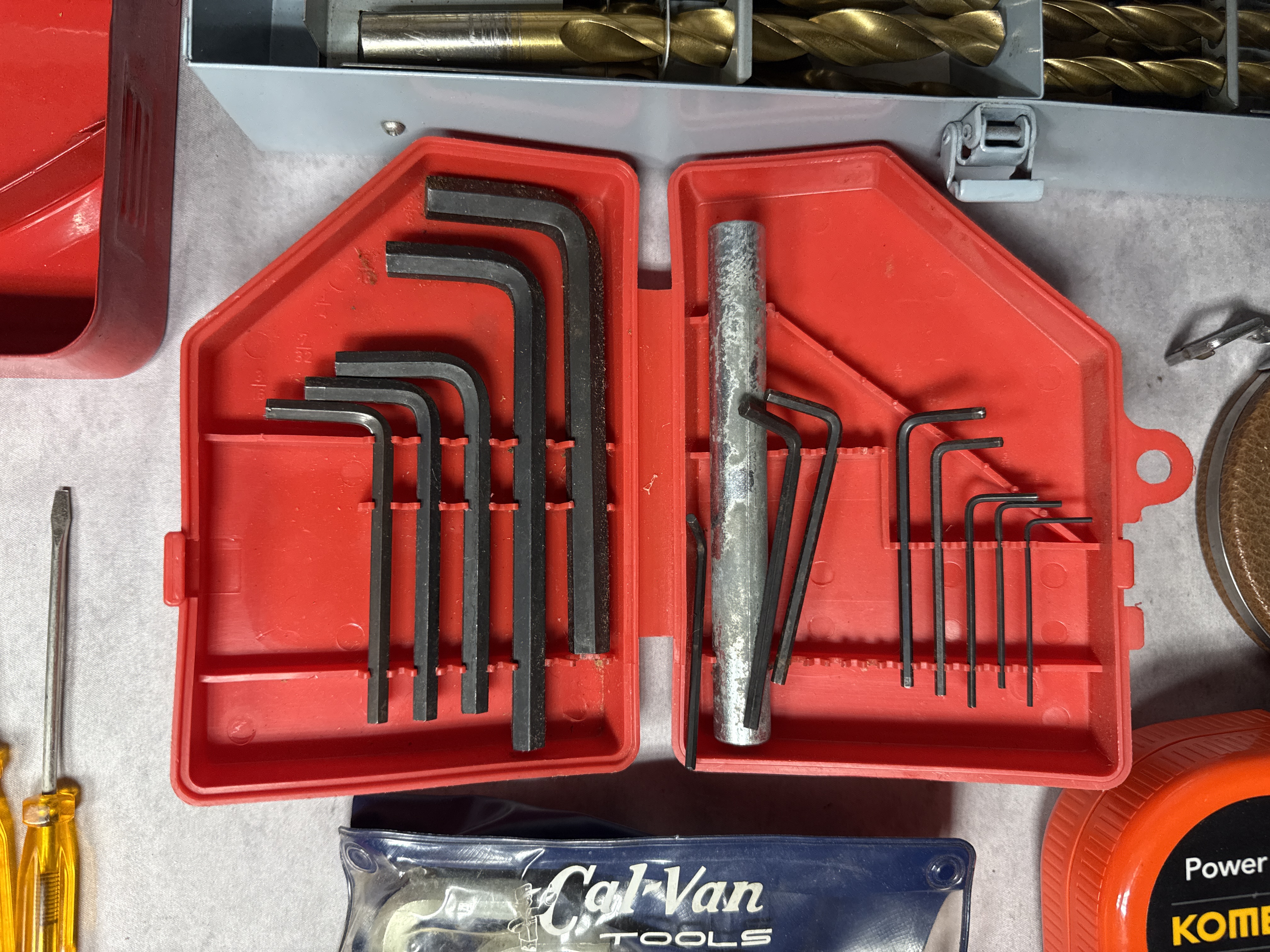 An Assortment of Workshop Hand Tools Including Drill Bit Sets, Hex Keys, and Tape Measures