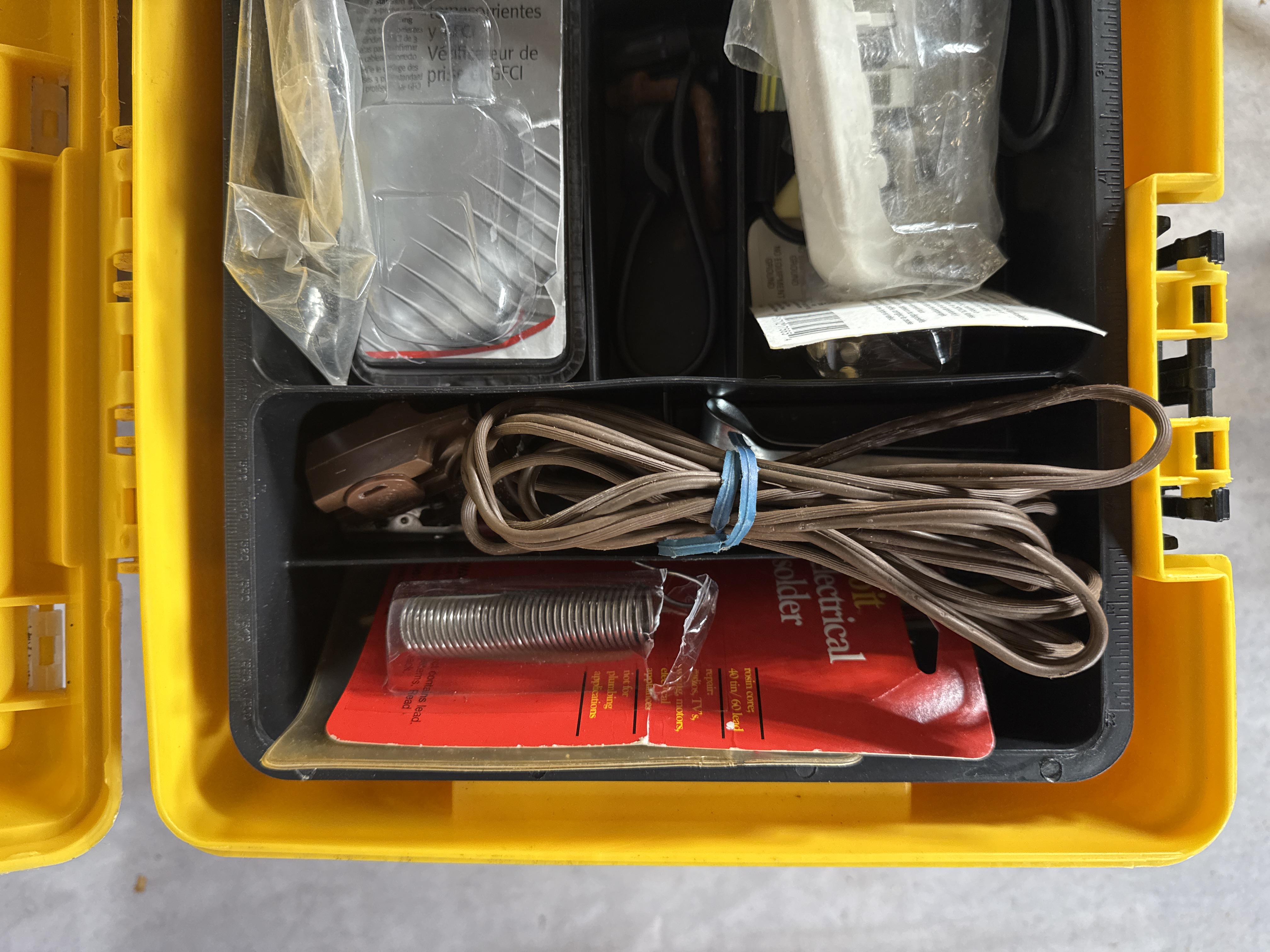An Assortment of Electrical and Networking Tools and Supplies with a Yellow Plastic Toolbox