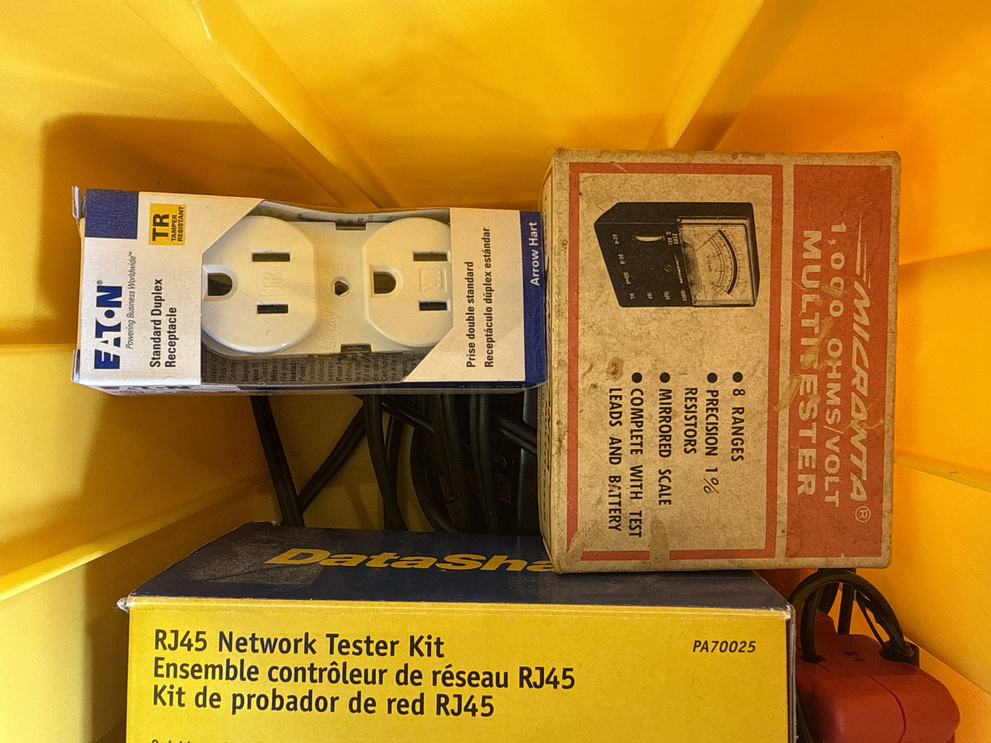 An Assortment of Electrical and Networking Tools and Supplies with a Yellow Plastic Toolbox