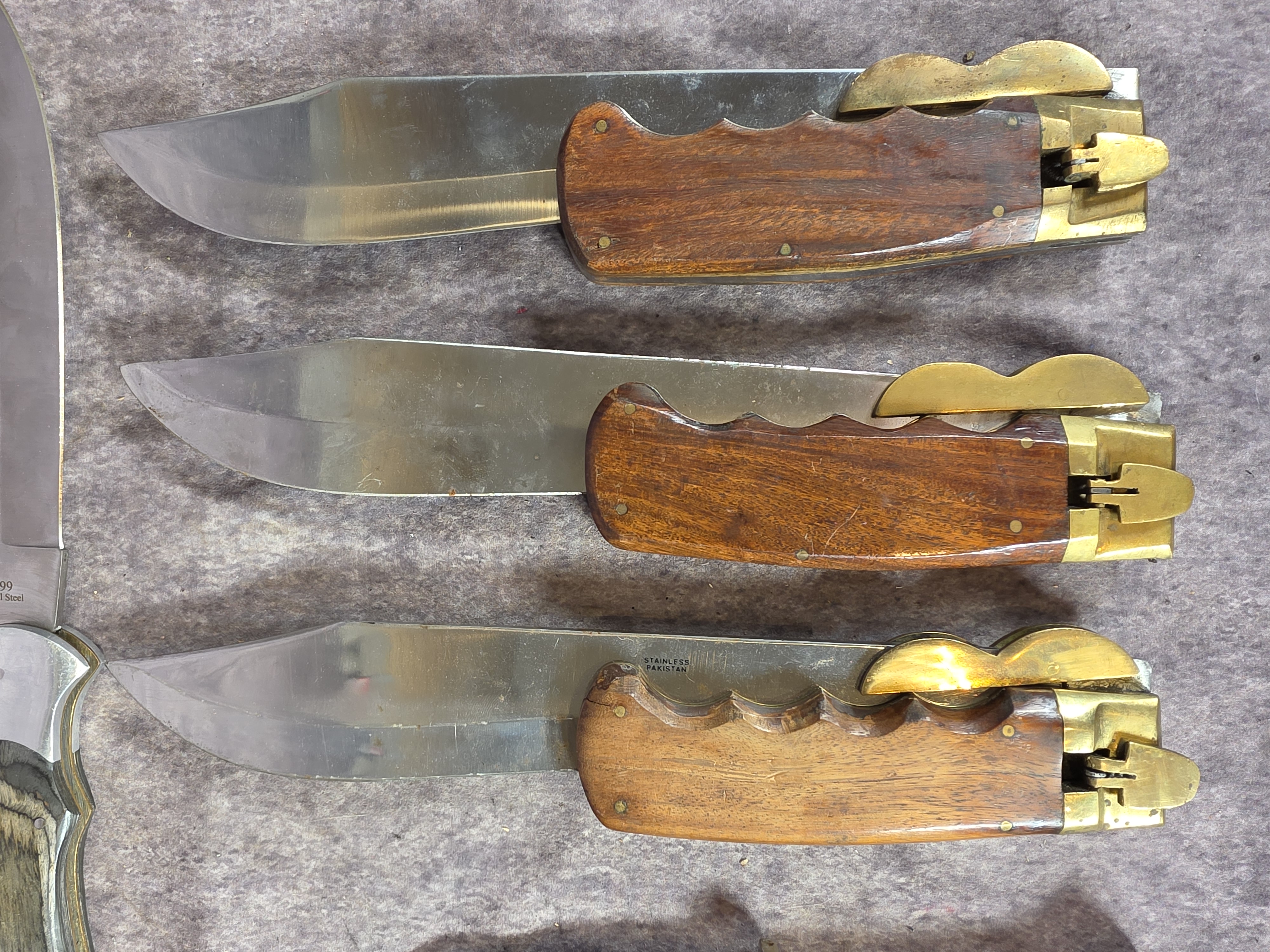 A Collection of Eight Oversized Folding and Fixed Blade Knives from Pakistan and China