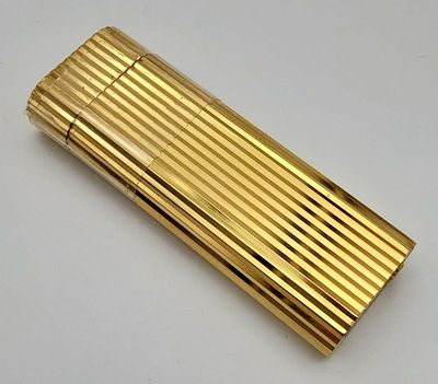 A Vintage Cartier Gold Plated Lighter. Geometric ridged pattern. In need of gas and flint. UK 