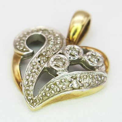 A 9K YELLOW GOLD DIAMOND SET HEART PENDANT / CHARM. 1.1G. 18MM.