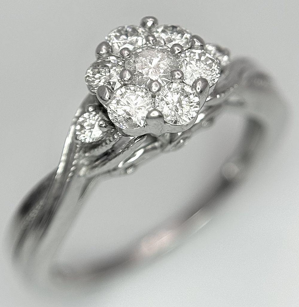 A 9k white gold, diamond cluster ring, 0.20ct diamond, 3.1g total weight, size J. 2613H.