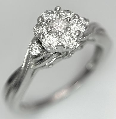 A 9k white gold, diamond cluster ring, 0.20ct diamond, 3.1g total weight, size J. 2613H.