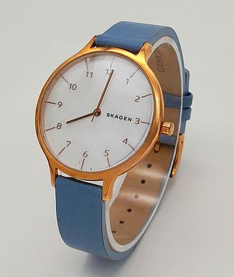 A Skagen Quartz Ladies Watch. Blue leather strap. Gilded case - 37mm. Mother of Pearl Dial. In