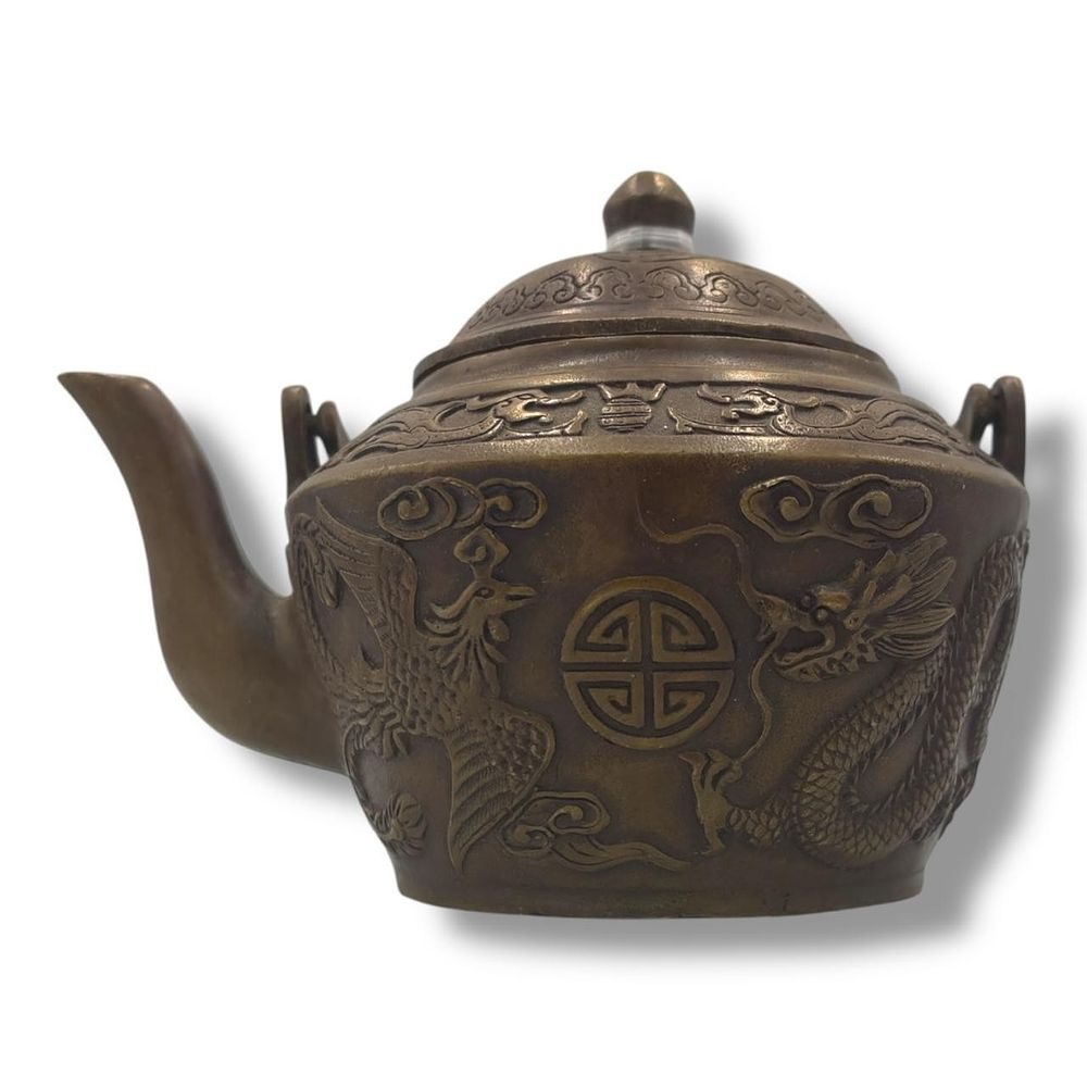 An antique Chinese Qianlong Bronze Dragon and Phoenix Teapot. Patinated bronze featuring raised 
