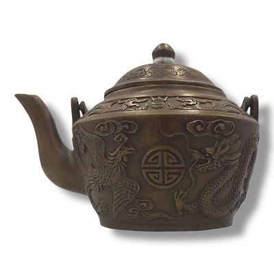 An antique Chinese Qianlong Bronze Dragon and Phoenix Teapot. Patinated bronze featuring raised