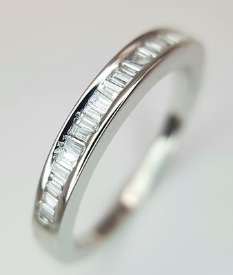 AN 18K WHITE GOLD DIAMOND SET HALF ETERNITY RING. BAGUETTE CUTS DIAMONDS 0.25CT. 2.7G TOTAL