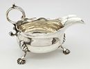 An Antique Georgian Sterling Silver Sauce Boat. C scroll handle and standing on three webbed Image - 1