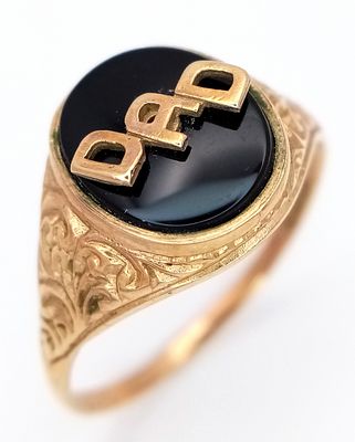 A 9K GOLD "DAD" RING WITH RAISED GOLD LETTERS ON A BLACK ONYX BACKGROUND . 3.3gms size X