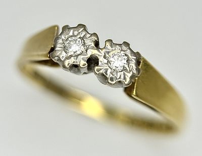 AN 18K GOLD RING WITH TWIN ILLUSION SET DIAMONDS . 2.7gms size N