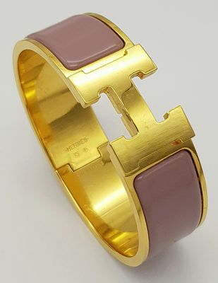 A HERMES CLIP OPEN BANGLE WITH THE FAMOUS "H" CLASP FLANKED BY 2 LILAC ENAMEL RECTANGLES .