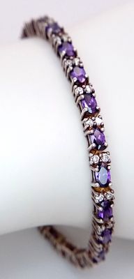 A stunning 925 silver Amethyst and CZ tennis bracelet. Total weight 12.1G. Total length 20cm.