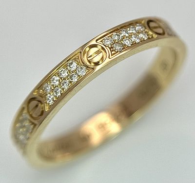 An 18K Gold and Diamond Pave Cartier Love Band Ring. 4mm width. Size 50. 2.1g. Comes with a 
