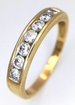 An 18K Yellow Gold Diamond Channel Set Ring. Seven round brilliant cut diamonds - 0.50ctw. Size 