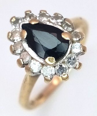 A 9K Yellow Gold Diamond and Sapphire Ring. Pear cut sapphire with diamond surround. Size J. 2.73g.
