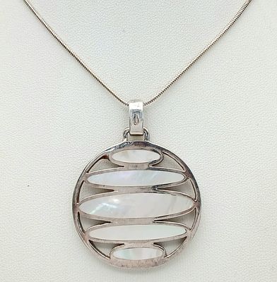 A sterling silver Mother of Pearl circular design pendant, set on a silver necklace. Total 