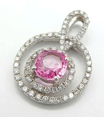 An 18K White Gold, Pink Sapphire and Diamond Pendant. A c.1ct mesmerising pink sapphire with a 