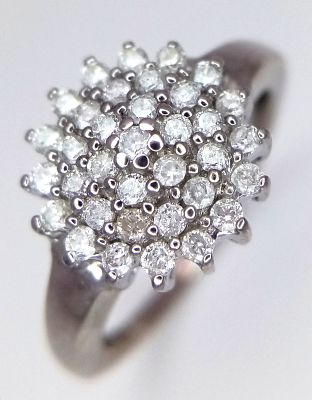 A 9K WHITE GOLD DIAMOND SET CLUSTER RING. 0.25CTW. 3.9G. SIZE O. SC4034.