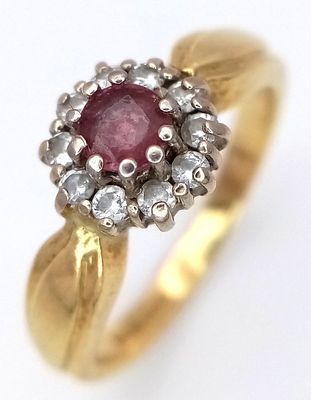 An 18K Yellow Gold Ruby and Diamond Ring. Round cut ruby with a diamond surround. Size N. 4.35g.