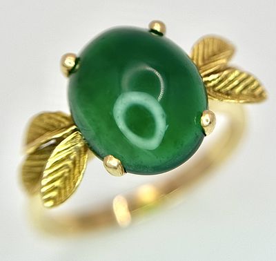 AN 18K GOLD DESIGNER RING WITH A CENTRAL JADE CABOCHON CLAW SET . 4.3gms size O