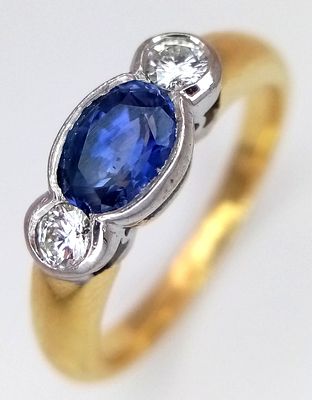 An 18K YELLOW GOLD DIAMOND AND SAPPHIRE RING 0.30CT DIAMONDS AND 0.50CT OVAL SAPPHIRE 5.3G SIZE 