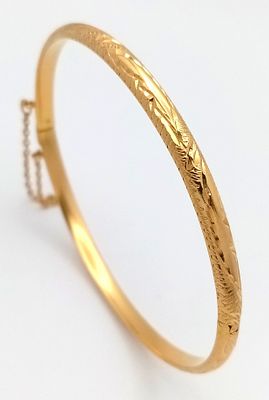 An 18k yellow gold engraved bangle, 8g total weight, 6cm bangle diameter. Ref: 1624I.