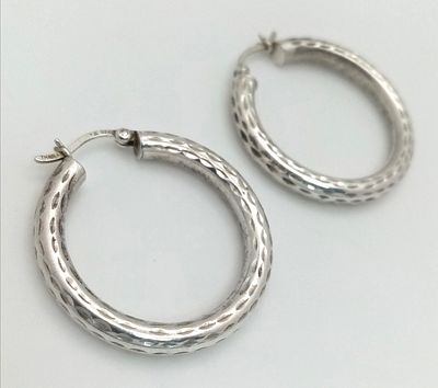 A 925 silver pair of textured fashion hoop earrings. Total weight 3.4G.