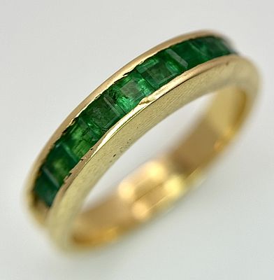 An 18K Yellow Gold Channel Set Emerald Ring. Size O. Nine square shaped emeralds. 5.8g. N10/24756.