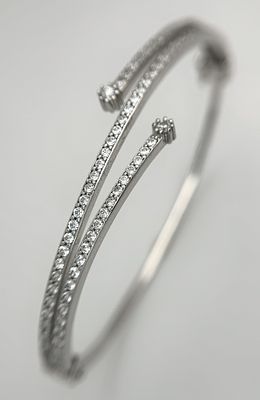A 14K White Gold and Diamond Crossover Bangle Bracelet. c.100 micro-claw pave set diamonds of 