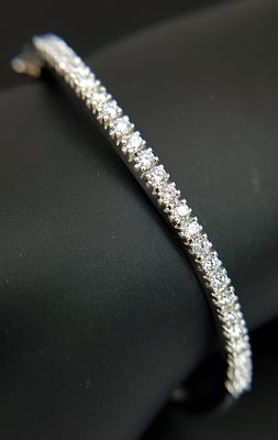 An 18K White Gold (tests as) and Diamond Wave Bangle. 0.87ctw or round brilliant cut diamonds 