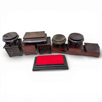 A set of assorted Chinese carved hardwood display stands in various shape: round, rectangular 