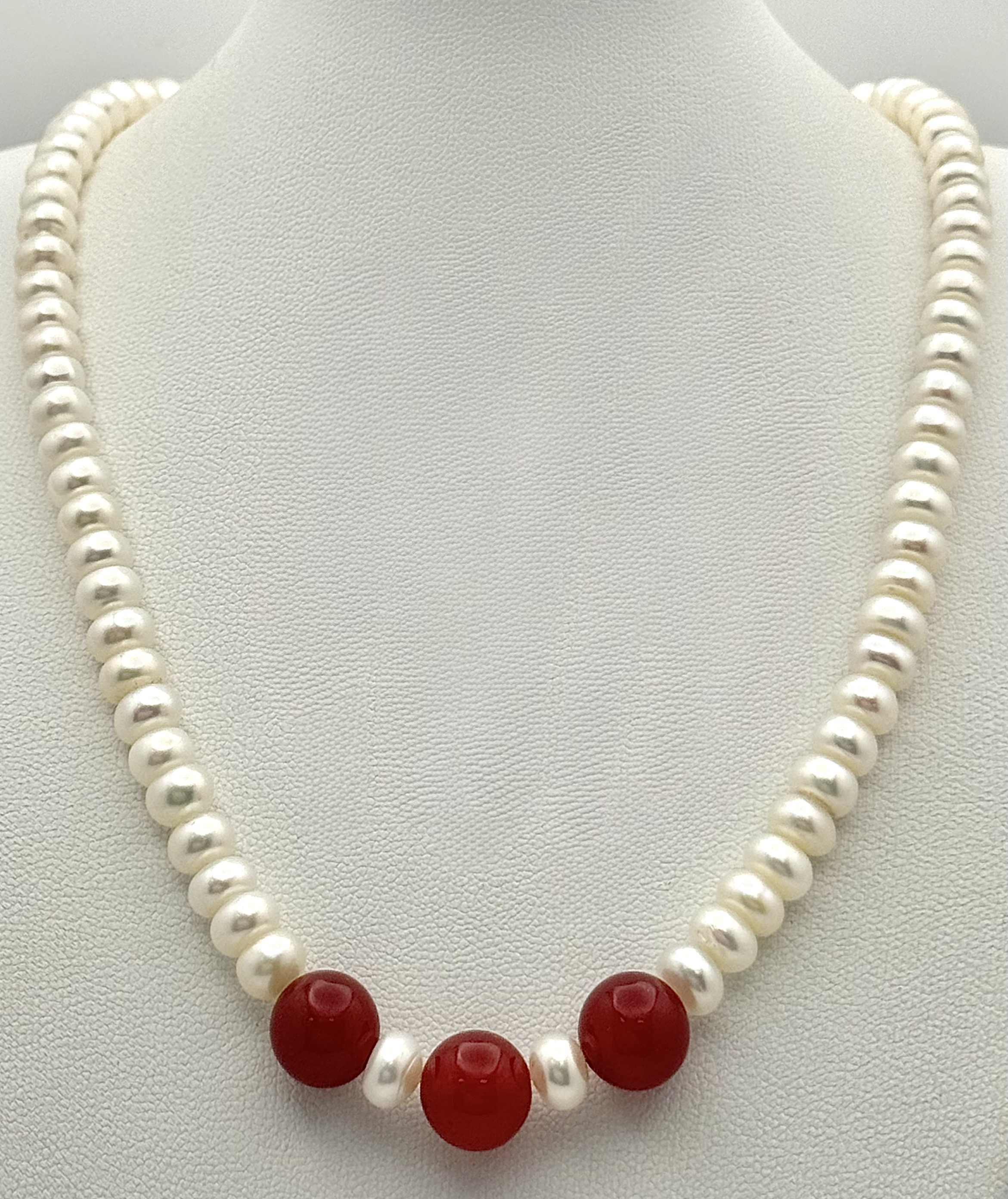 A pretty single strand of white Freshwater Pearls and red Agate stone highlight
