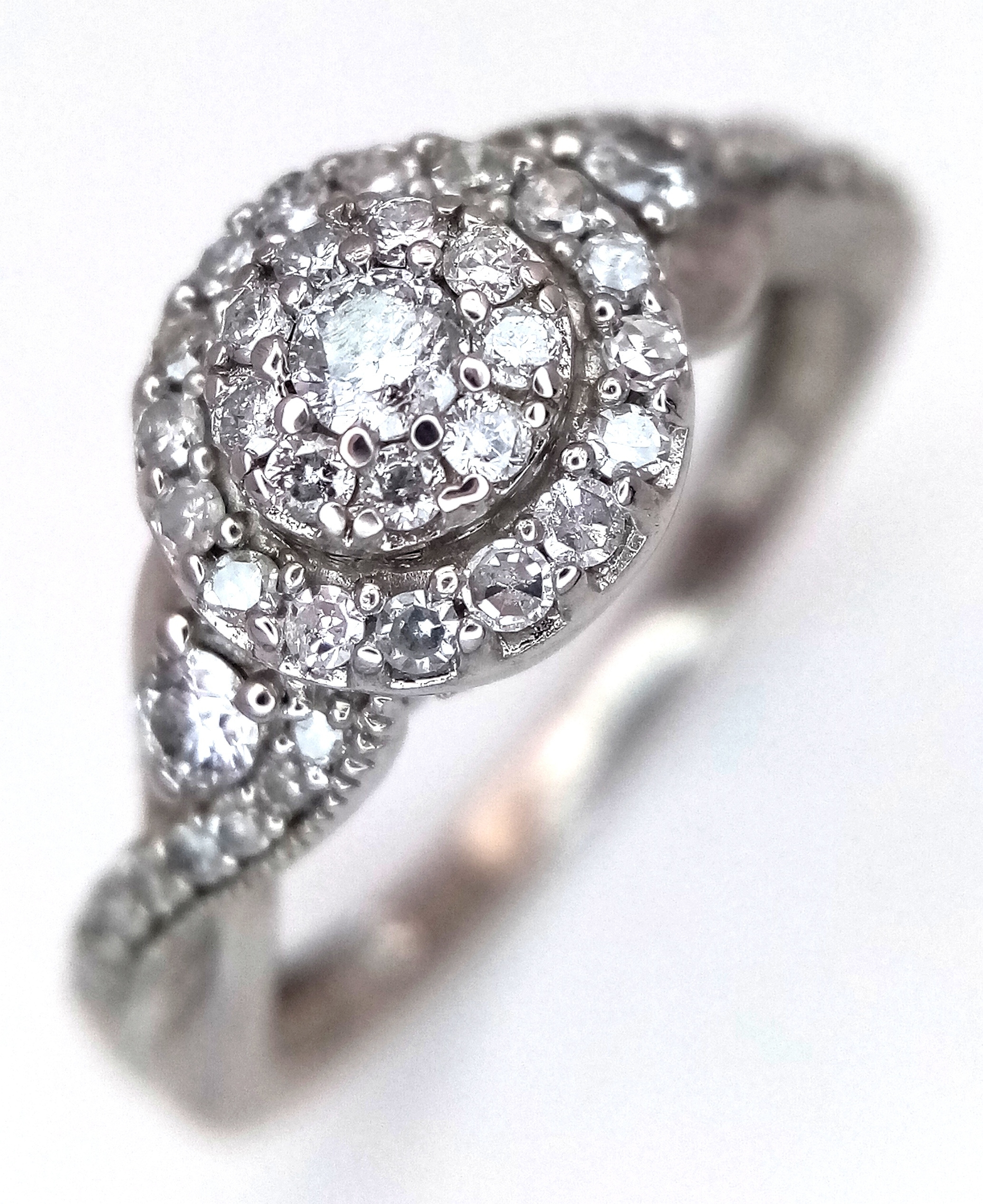 A 9K WHITE GOLD, DIAMOND SET, TWIST SHOULDERS, CLUSTER RING